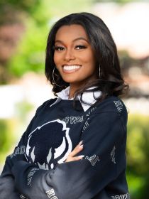 Brittney smiling in front of a blurred nature background